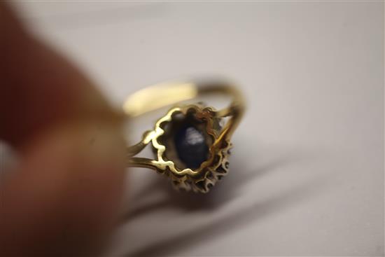 A cabochon sapphire and diamond cluster ring, size N.